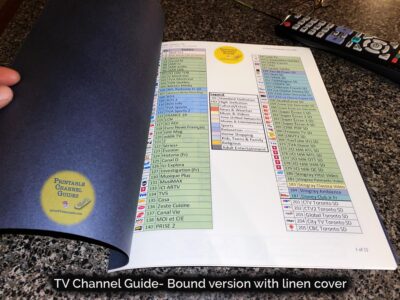 Colour-coded, printed channel guide bound with attractive blue linen covers. First page of guide seen. Caption reads, “TV Channel Guide - bound version (linen cover)”